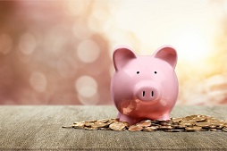 a pink piggy bank with change all around.